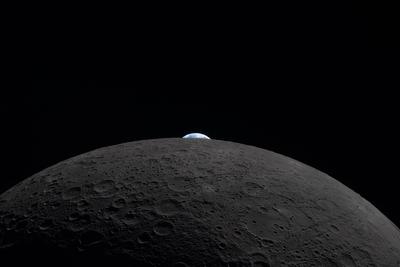 Earthrise over the lunar horizon, wide view